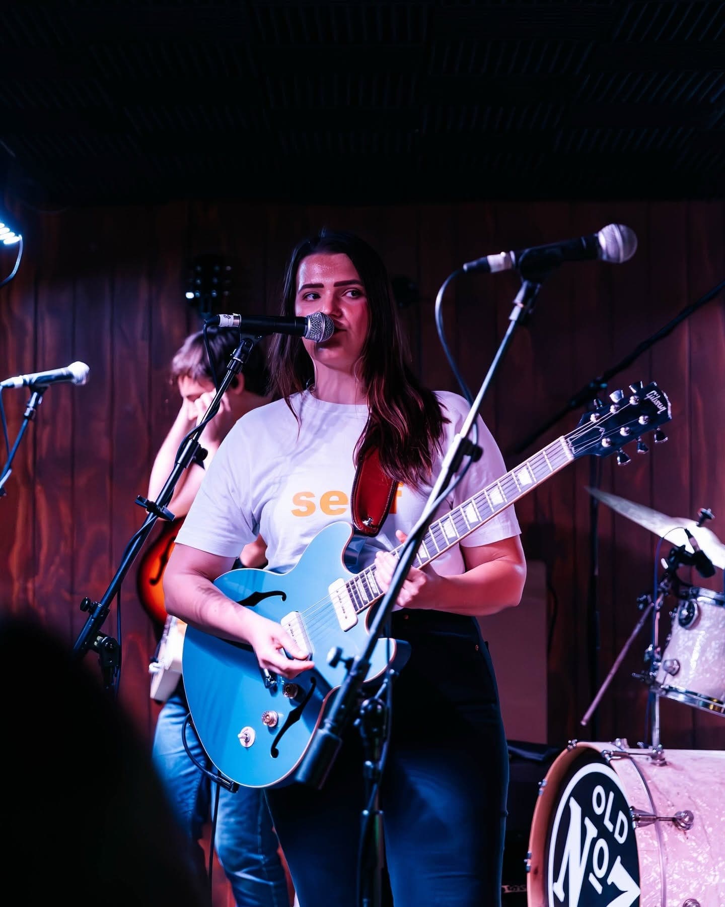 Singer playing a blue guitar on stage