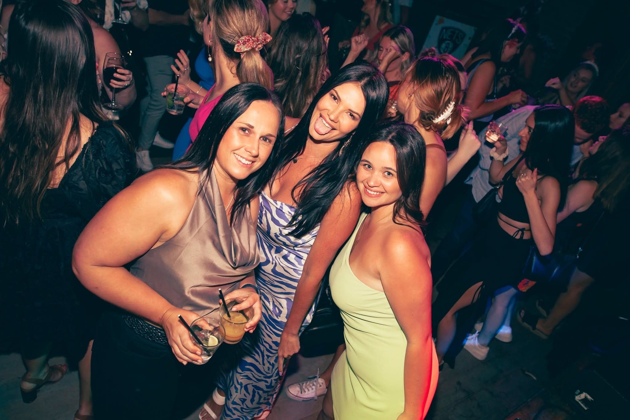 Three friends posing with drinks