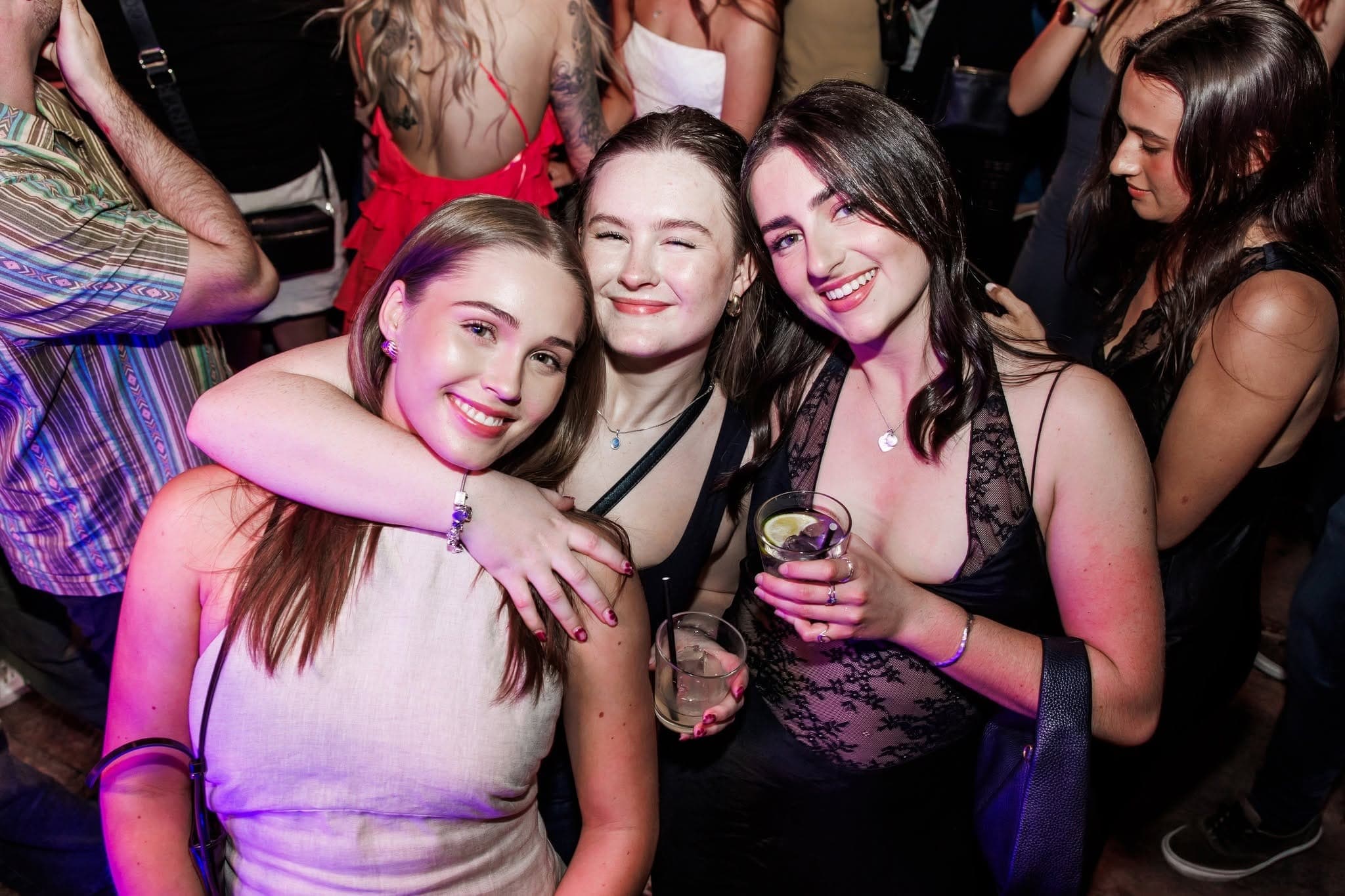 Three friends hugging on the dance floor