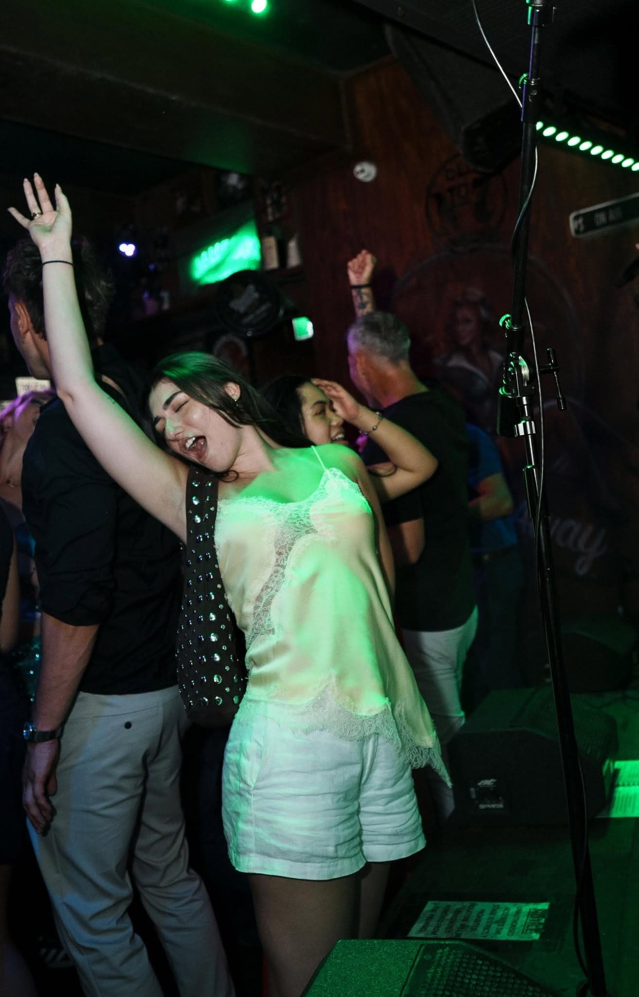 Woman dancing under green lights